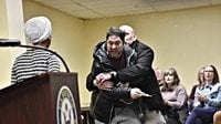 Rep. Ilhan Omar rushed by man on stage and sprayed with liquid at town hall event