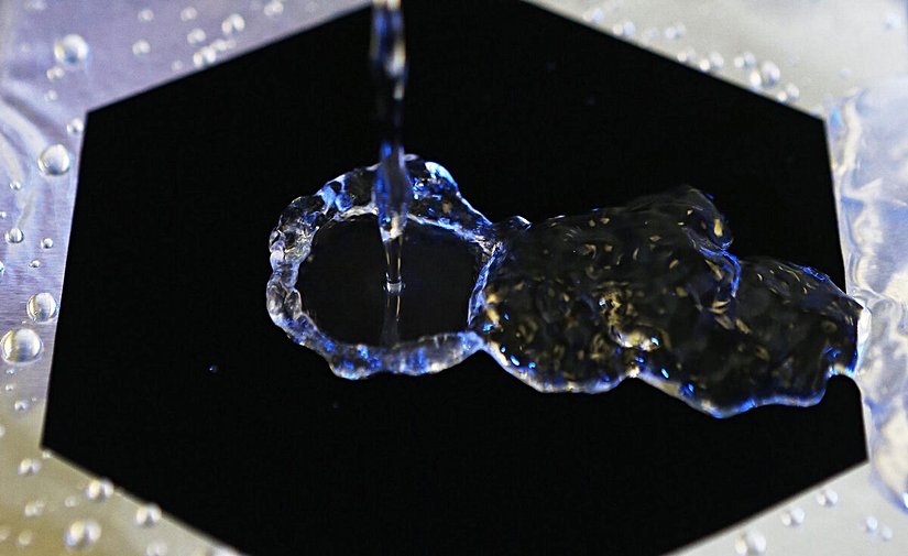 Bu görüntüde, Vantablack'in ışığı nasıl emdiği ve su damlasının yüzeyde neden farklı göründüğü dikkat çekiyor. Vantablack, ışığı %99,9 oranında soğurarak, herhangi bir yansıma oluşturmuyor. Buna karşın, su damlası üzerinde ışığın yansımaları açıkça görünüyor.