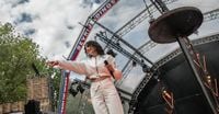Op het Bevrijdingsfestival in Wageningen viert de een de vrijheid met een biertje in de hand, de ander met  spandoek en rode flyer