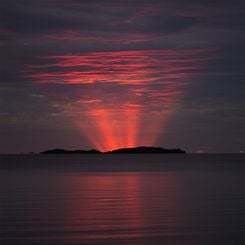  Red Crepuscular Rays from an Eclipse 