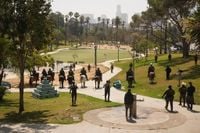 Photos of federal officers descending on a Los Angeles park as residents and mayor watch