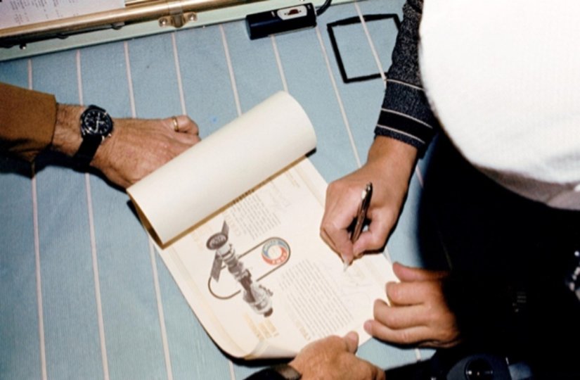 Kozmonot Valery Kubasov Apollo-Soyuz Ortak Test Projesi sertifikasını imzalarken