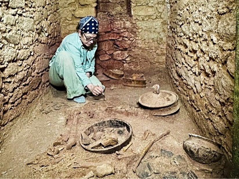 Arkeolog Diane Chase ve meslektaşları, Caracol'daki mezarın, aralarında kırmızı bir mineral olan sinabarın (arka plan), çanak çömleklerin (ön plan) ve nadir bir yeşim maskesinin (solda) de bulunduğu mezar eserlerine dayanarak Maya toplumunun seçkin bir üyesine ait olduğunu düşünüyorlar.