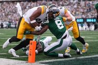 NFL fans left bemused as individuals spotted crawling across a 100-foot USA flag before the Jets hosted the Steelers