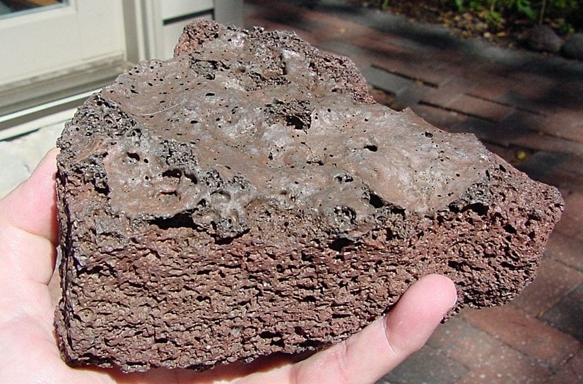 New Mexico'dan bir veziküler bazalt örneği. Bir önceki fotoğrafta olduğu gibi, üstteki camsı kabuk, erimiş lavın havaya maruz kaldığı ve hızla soğuduğu yerdir. Bir göktaşı füzyon kabuğu değildir. Bazaltlar, çoğunlukla gri veya siyahtan pas rengine kadar çeşitli renklerde gelir.